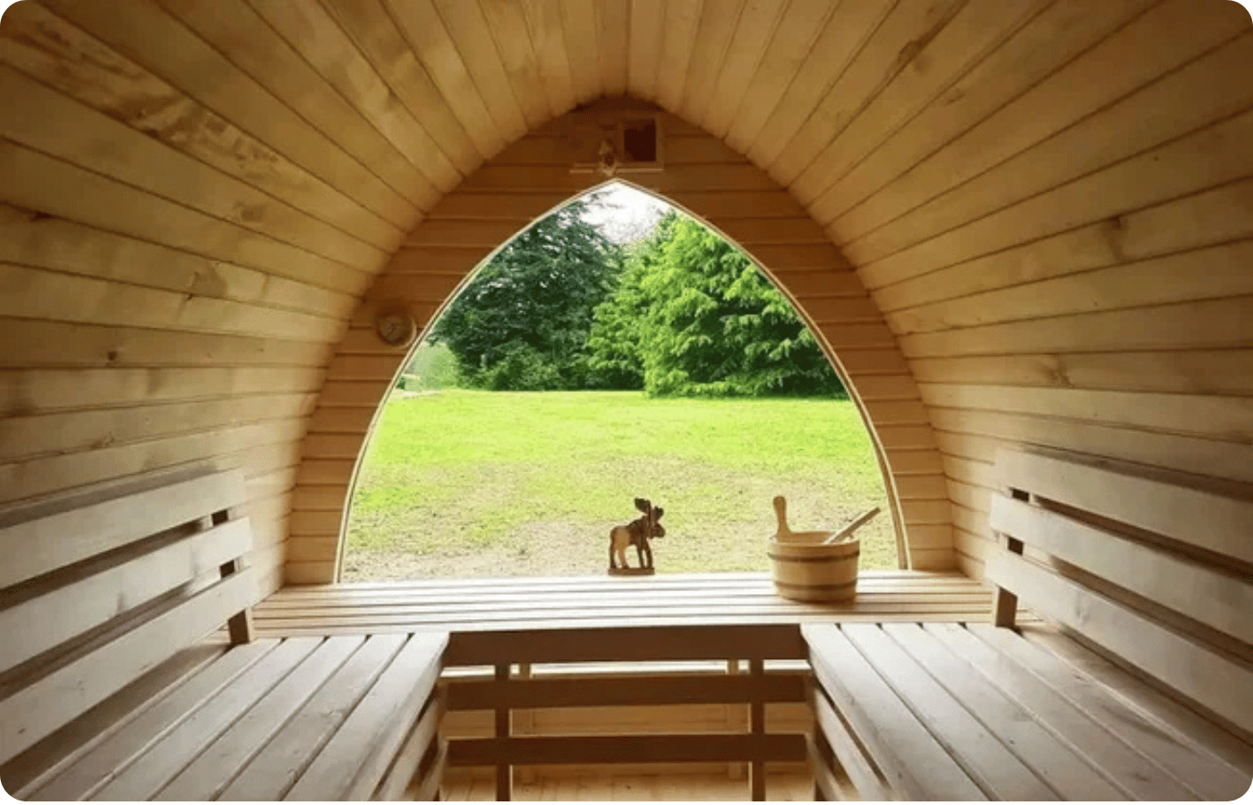 Où faire une retraite yoga en France ? 4 Intérieur d'un sauna en bois avec vue sur prairie verdoyante, espace bien-être de la retraite yoga Moon Yogatherapy en Dordogne