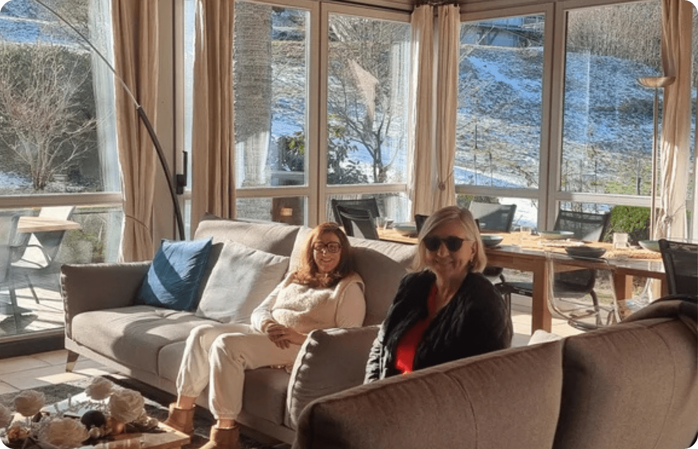 Où faire une retraite yoga en France ? 8 Deux participantes détendues dans le salon vitré du Chalet Terejo face aux Vosges enneigées, retraite yoga France