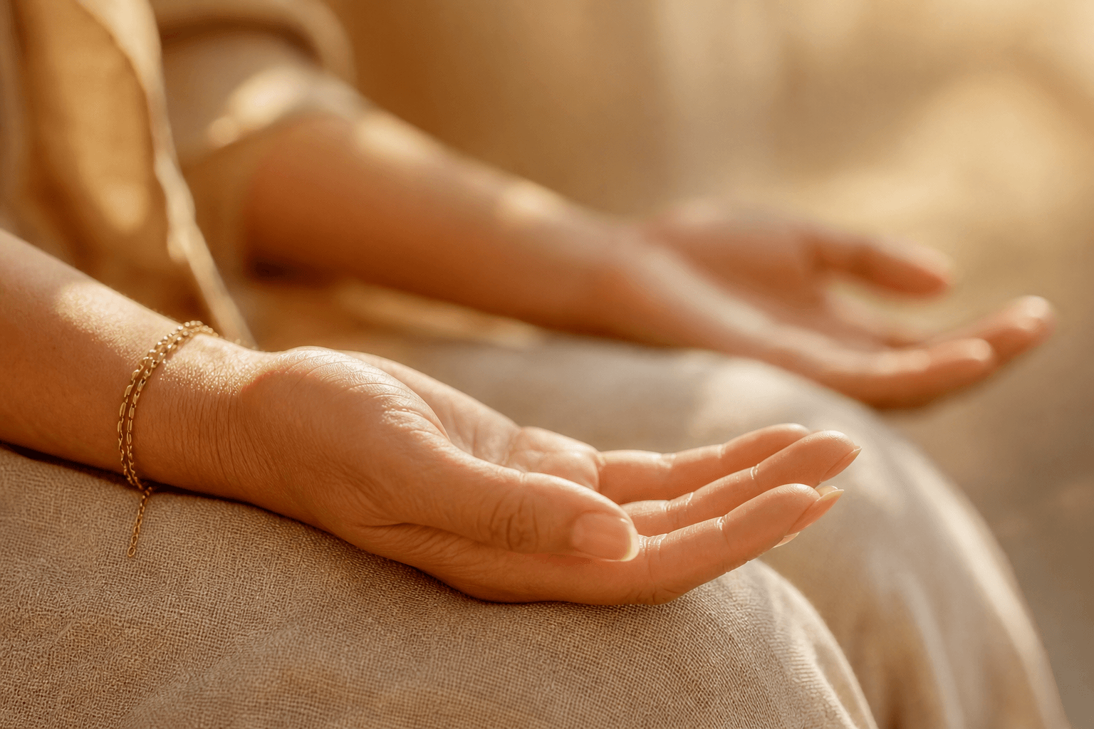 Gros plan sur des mains ouvertes posées sur un genou, texture lin naturel, lumière douce — pratique méditation débutante