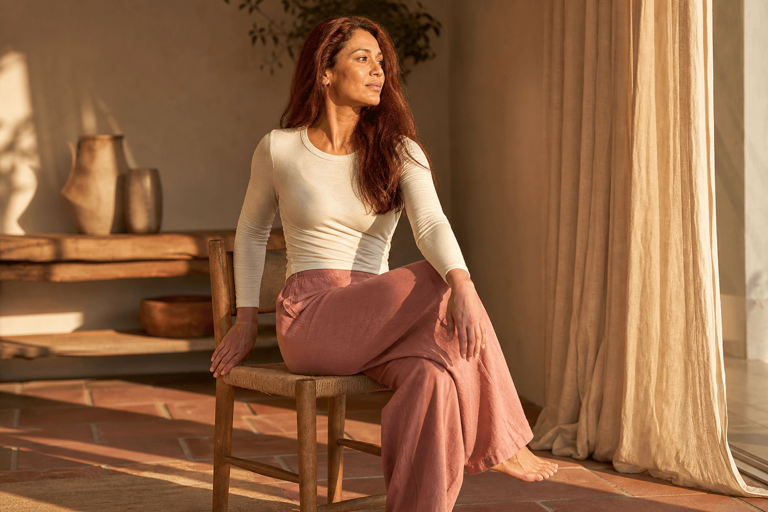 Yoga sur chaise : 6 postures essentielles 2 Femme en posture de torsion assise sur une chaise en bois, main sur le genou opposé, yoga sur chaise mobilité du dos