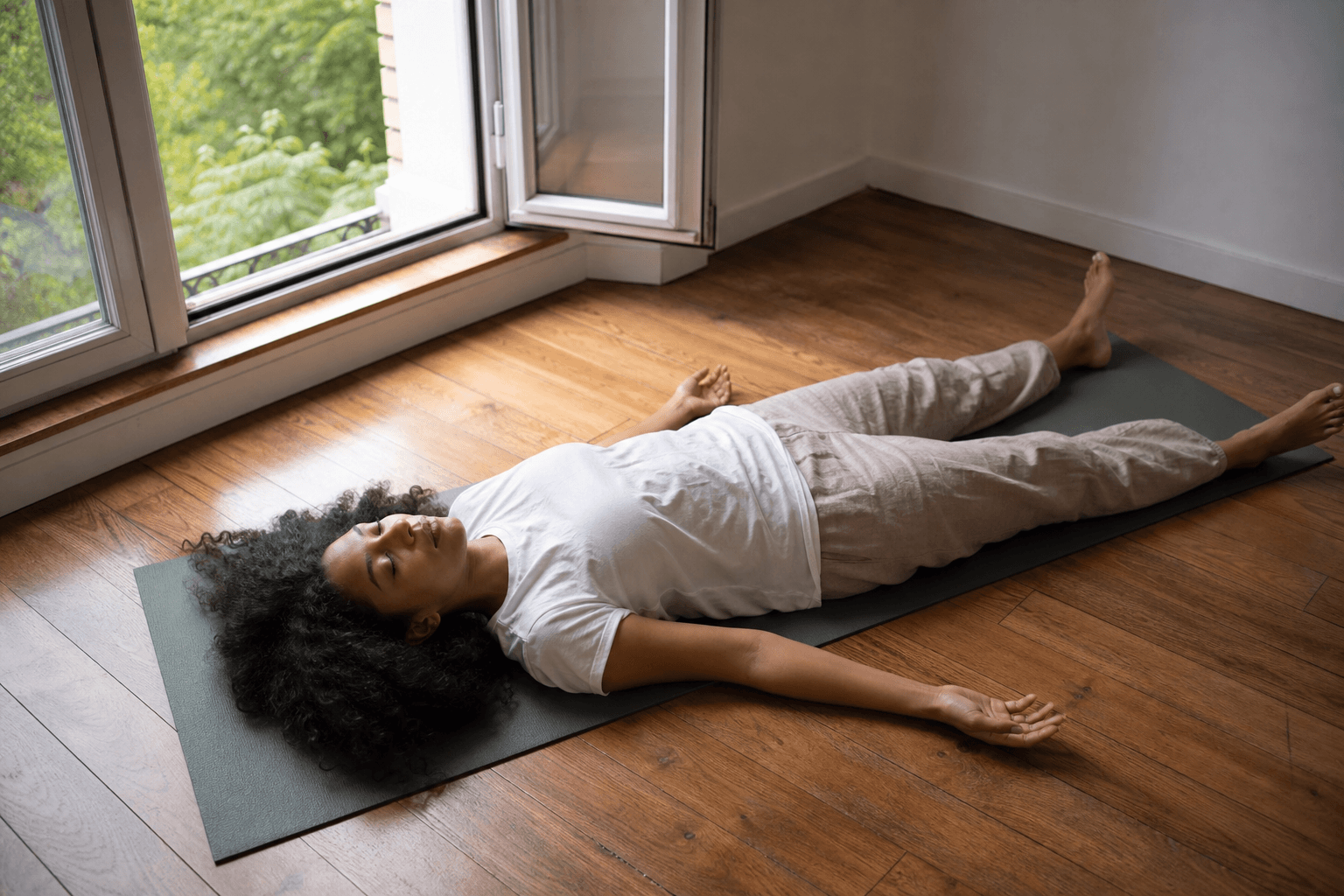 Chakra couronne : 5 signes de blocage et comment l'équilibrer 1 Femme en Savasana près d'une fenêtre, lumière naturelle douce, abandon profond, méditation chakra couronne